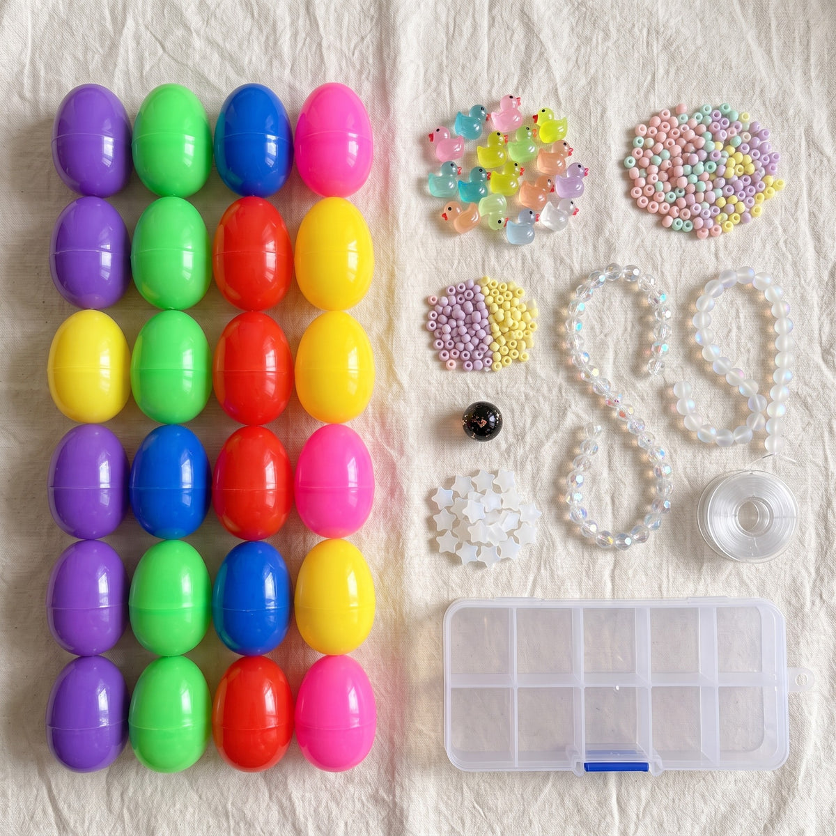 Everything in One Bowl laid out: 24 capsule eggs, glass beads, glow ducks, the lucky bead, a bead box and cord